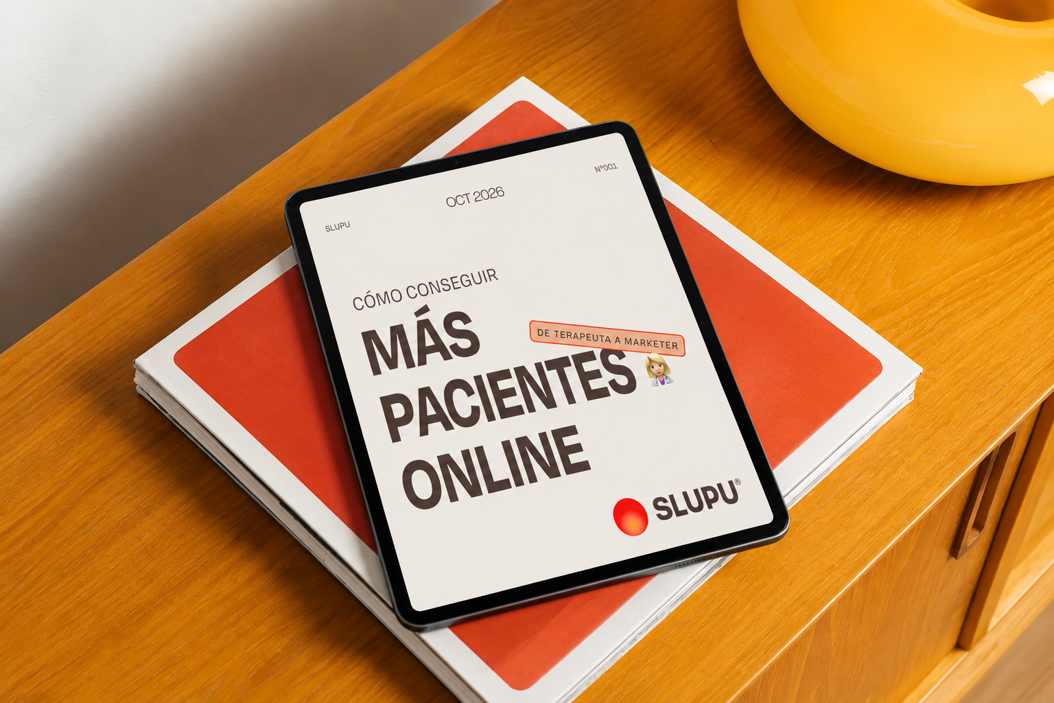 Ebook Cómo conseguir más pacientes online de SLUPU en una tablet sobre una mesa naranja